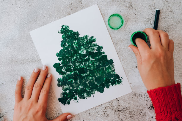 DIY制作贺卡为孩子们制作节日手工工艺品。用手指画画，圣诞树快乐。一步一步。圣诞树装饰新年快乐图片下载