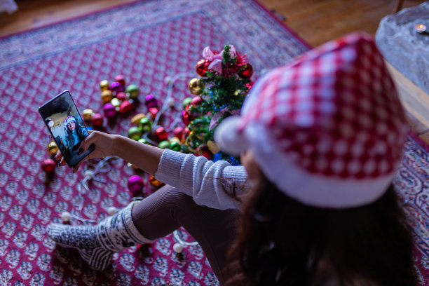 在圣诞节假期，一位宁静的女士带着圣诞帽自拍图片下载