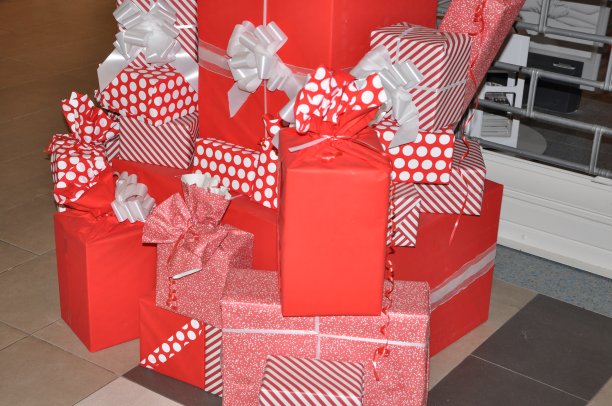 红白相间的礼品盒堆在一起。圣诞树下的节日礼物。图片下载