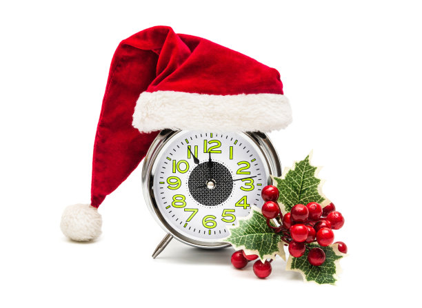 新年或圣诞卡片:闹钟在圣诞老人的帽子和冬青在白色的背景。孤立的图片下载