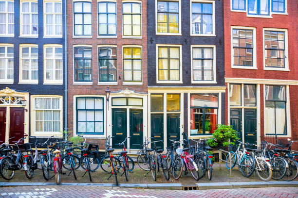 阿姆斯特丹一条传统老街的细节——倾斜的老房子、窗户、门和许多停放的自行车。欧洲的历史建筑。背景。图片下载