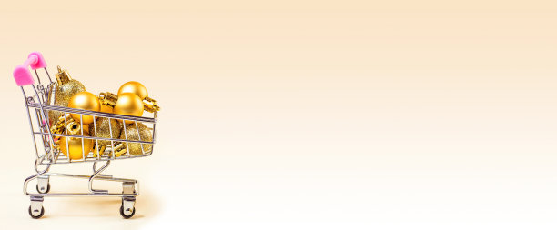 购物车与金色的圣诞装饰物横幅在灯光的背景与复制空间。圣诞节大减价，打折，假日购物，买礼物和礼物的概念图片下载