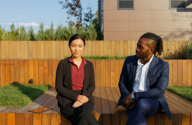 非裔美国男性和亚裔女性坐着交流图片下载