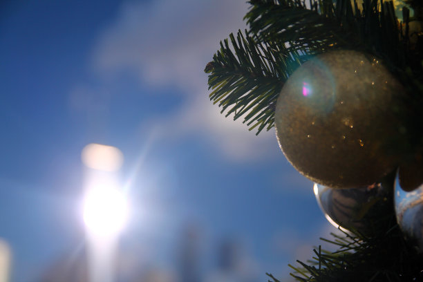 近距离观察圣诞装饰，光线反射在建筑的背面，天空湛蓝图片下载