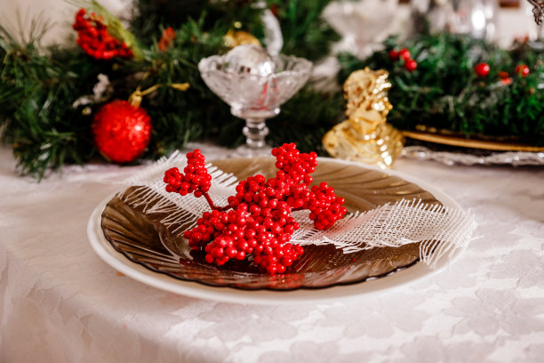 美丽的圣诞假期背景与红色饰品，冬青浆果，蝴蝶结和圣诞装饰复古风格。圣诞装饰表。贺卡。圣诞家庭餐桌概念。表设置图片下载
