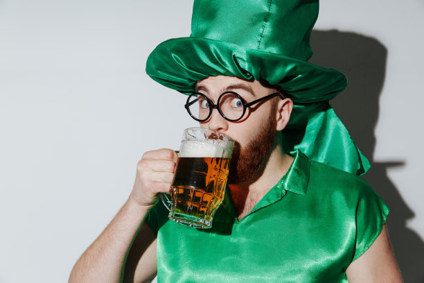 穿着圣帕特里克服装喝啤酒的快乐男人图片下载