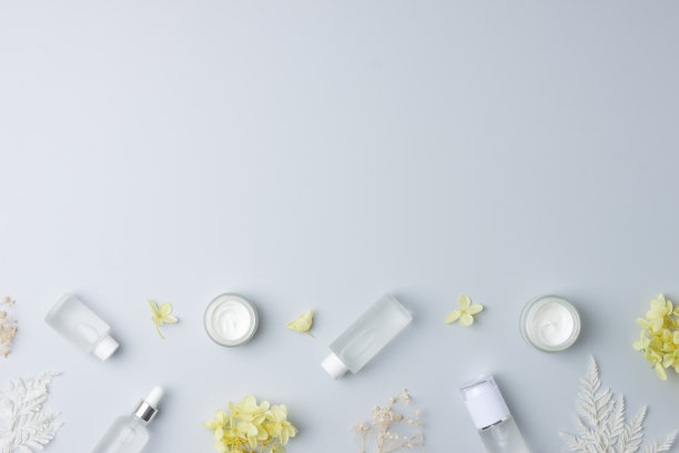 化妆品皮肤护理产品与花在灰色背景。平铺，复制空间图片下载