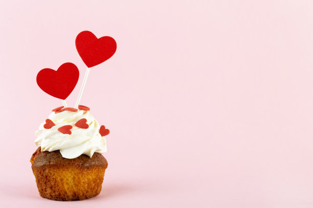 粉色背景上有心形的纸杯蛋糕，放置文字，情人节图片下载