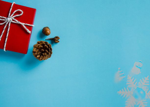圣诞背景红色的礼品盒，针叶球果，和橡子上的蓝色背景图片下载