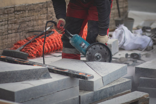 用切割机切割、锯切、磨磨花岗岩水泥瓦板的过程，在新建人行道沥青路面施工过程中，工人用圆锯切割陶瓷混凝土瓦图片下载