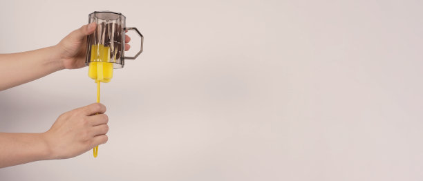 清洁和洗碗的概念。在白色背景上的男子洗手喝玻璃。用黄色软海绵棒清洗饮用玻璃。用海绵刷清洗杯子。新冠肺炎时代的消毒卫生图片下载