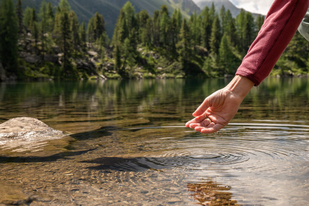 双手从高山湖泊中舀水图片下载