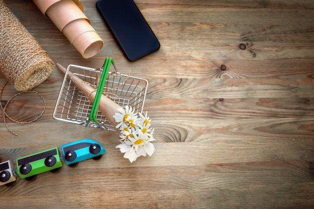 花束，电话，包装材料玩具汽车的木制背景图片下载