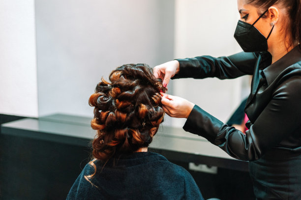 女老板在美容院做发型，并对着镜子看库存照片图片下载