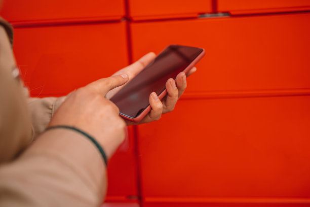 妇女从自动自助邮递终端机取信。包裹运输服务或送货包装概念图片下载