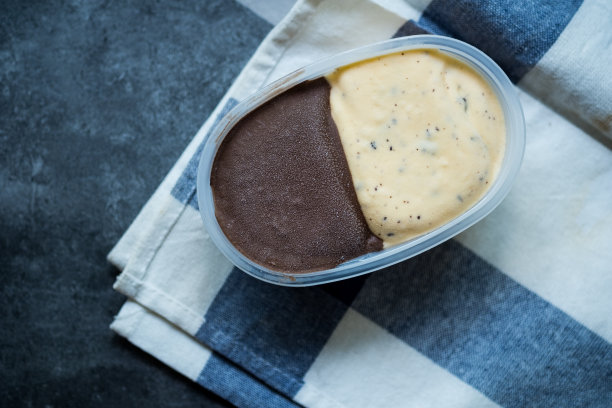 新鲜可口的棕色和黄色冰淇淋在容器。俯视图图片下载