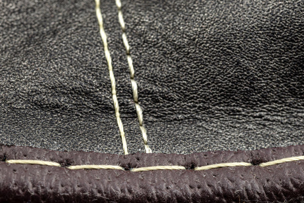 宏观背景制作黑色天然皮革与白色缝合在中心。图片下载