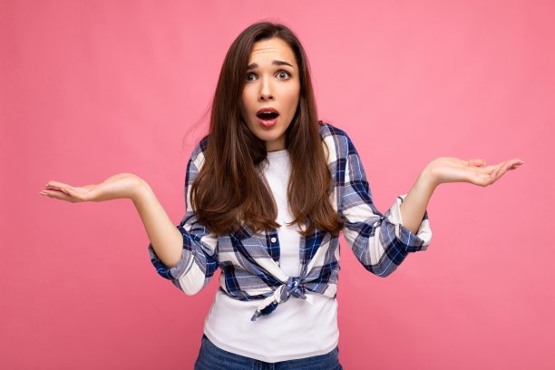 肖像照片的年轻惊讶惊讶美丽的黑发女人真诚的情绪穿着时尚的检查衬衫孤立在粉红色的背景与复制空间和有怀疑图片下载