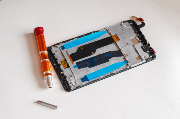 将智能手机、手动工具和零件拆卸在光线充足的表面上图片下载