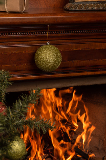 燃烧木材的壁炉，装饰着一个绿色的灯泡与霜，火焰的细节，室内一个舒适的地方图片下载