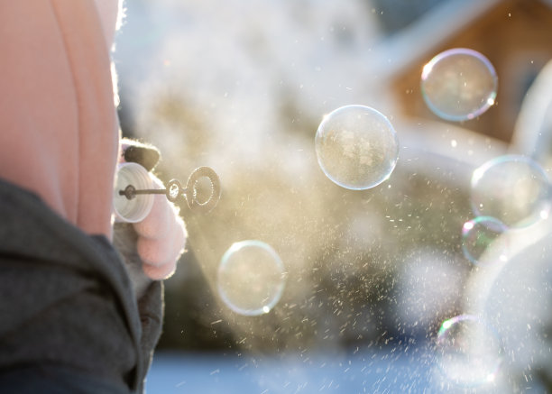 在阳光明媚的日子里，肥皂泡在冬天景观户外的背景上。图片下载