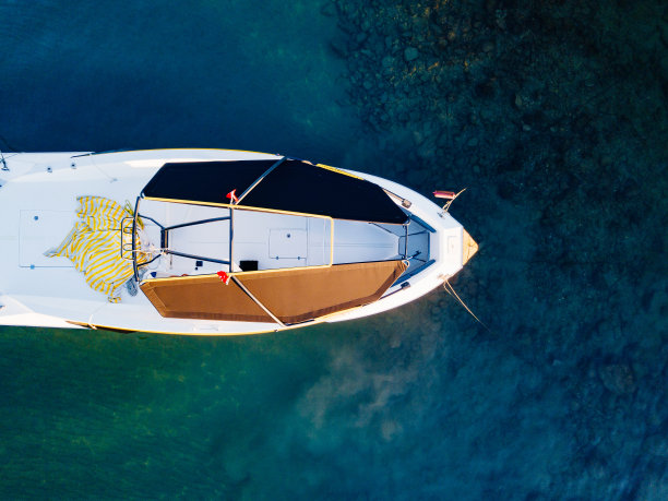 前视图。白色的小船映衬着蓝绿色的海水。图片下载
