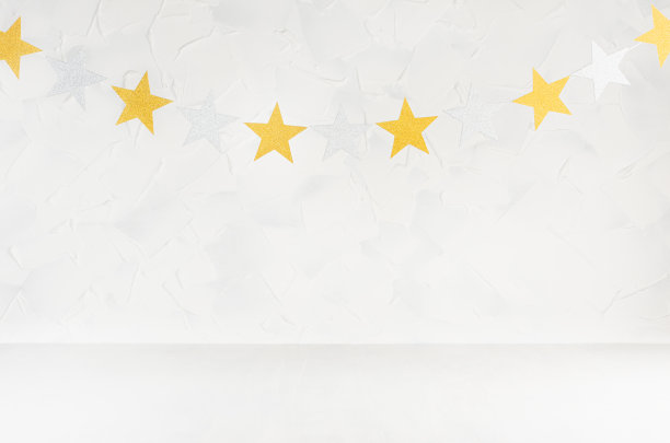 在柔和的浅色抽象室内，用金银闪烁的星星作为花环挂在绳子上。用于设计、展示、展示产品的空舞台。图片下载