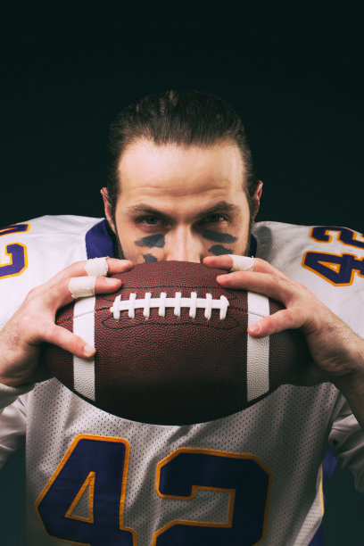 美国足球运动员的肖像，拿着球，看着相机图片下载