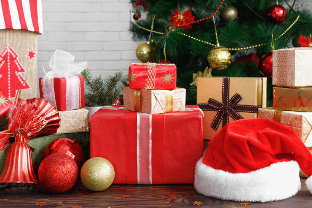 古董木桌上有珠子、玩具和圣诞老人帽子的礼品盒图片下载