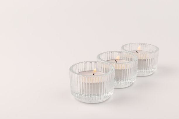 在杯架上燃着茶蜡烛，孤立在白色上。空间的文本图片下载