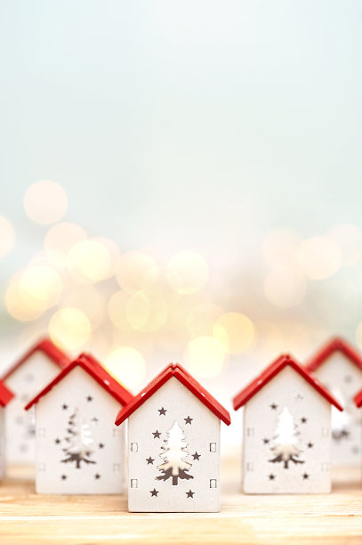 在散焦灯光背景下的小圣诞屋。垂直的照片。图片下载