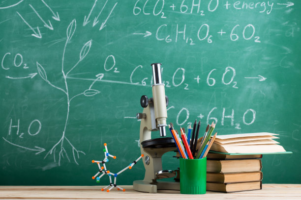 教育和科学概念书，分子模型和显微镜在礼堂的桌子上，黑板背景。图片下载