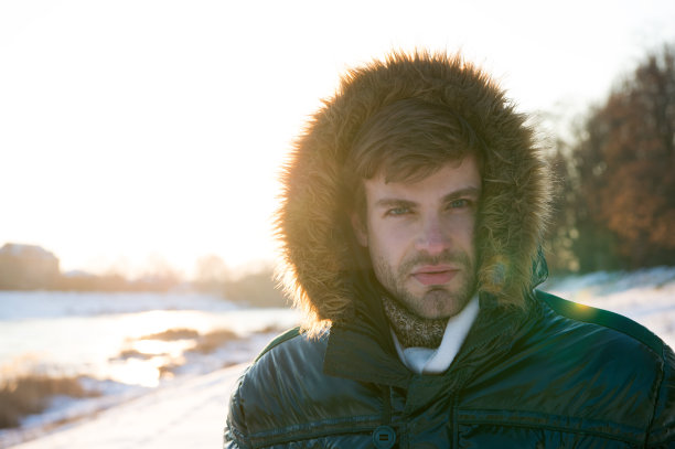 抗风的衣服。冬天的天气条件。极地探险家。阳光灿烂的冬日。冬季男装。冬天的衣服。潮人的时尚服装。家伙套罩。男人温暖的夹克下雪的自然背景图片下载
