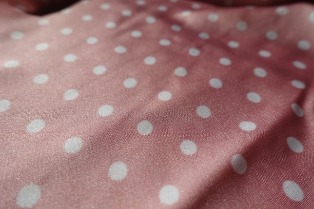 粉红和白色缎面聚酯织物与波尔卡点图案的特写图片下载