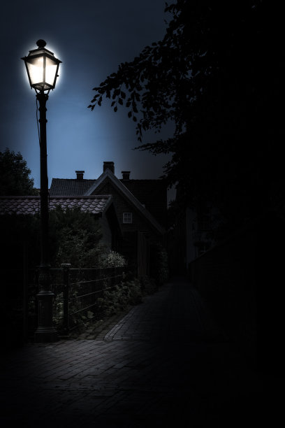 晚上在狭窄的铺路石路上点着路灯图片下载