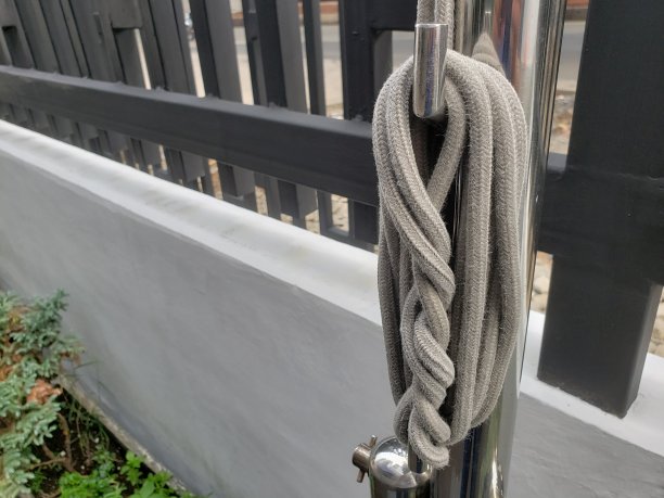 白色的绳子系在不锈钢杆上图片下载