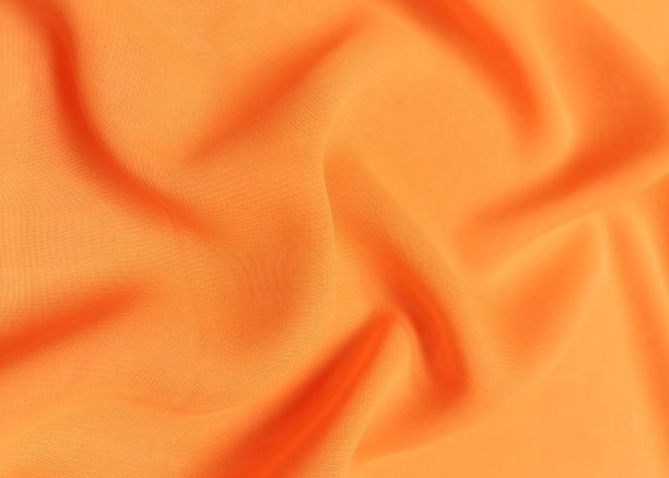 橙色皱巴巴或波浪形织物纹理背景。抽象亚麻布软波布。缎子、丝、棉的折痕。光滑优雅的丝绸或阿特拉斯豪华布纹理。被单或毛毯图片下载
