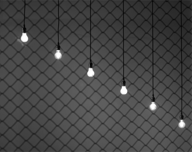 爱迪生灯透过金属格栅发出亮光。图片下载