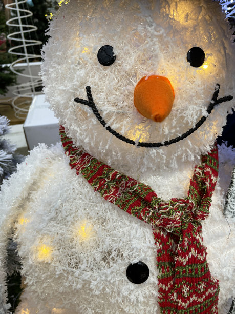 特写图像的可爱的真人大小的卡通雪人戴着围巾，季节性的冬季圣诞节展示，聚焦前景图片下载