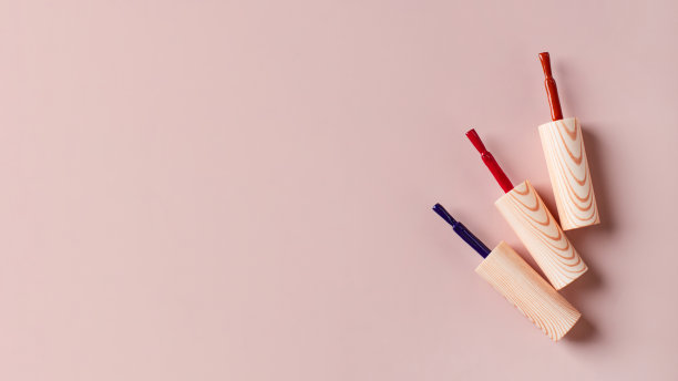 不同颜色的刷子明亮的指甲油瓶子浅粉色的背景。副本的空间。图片下载