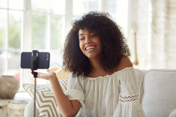 女非裔美国教师坐在家里用智能手机录制网络研讨会视频图片下载