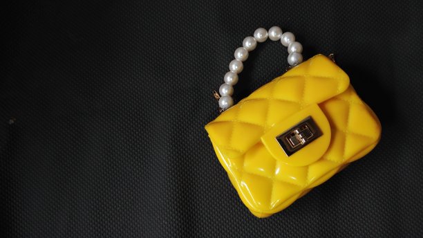 黄色可爱的儿童包珍珠带深色背景图片下载