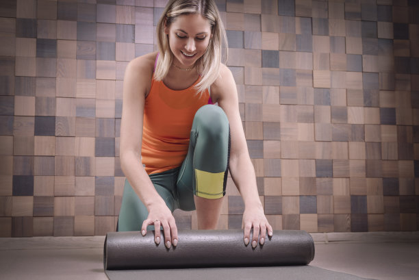 女人铺瑜伽垫准备训练图片下载