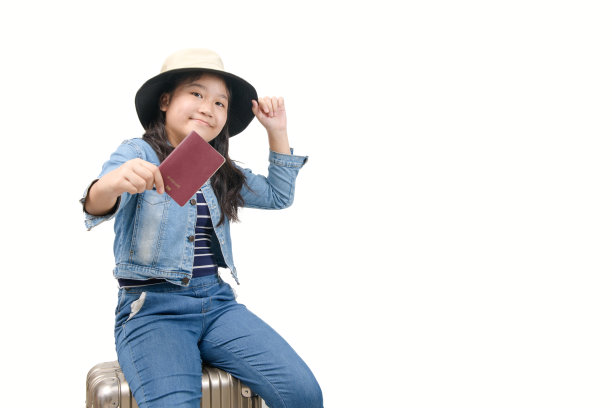 穿着牛仔裤的小游客坐在行李上，展示被隔离的护照图片下载
