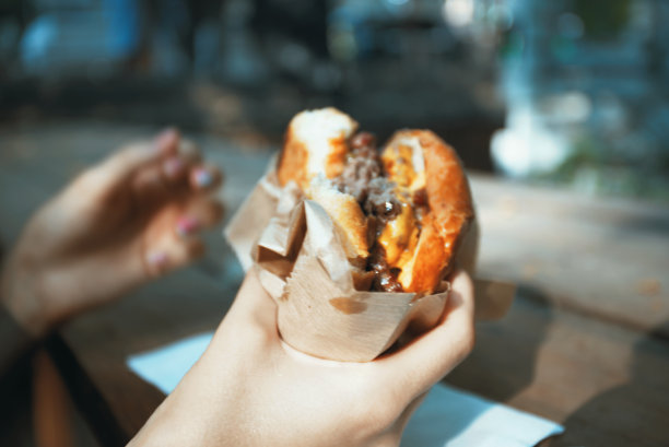 女人在户外吃汉堡图片下载