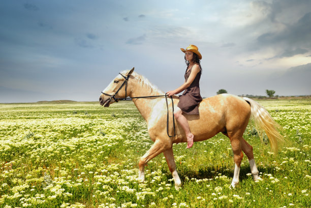 一个女人在草地上骑马图片下载