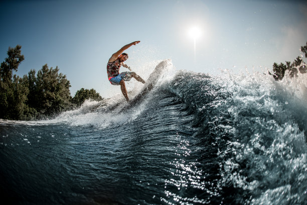 看到巨大的溅起水花的海浪的美丽景色，人们在翼板上保持平衡图片下载