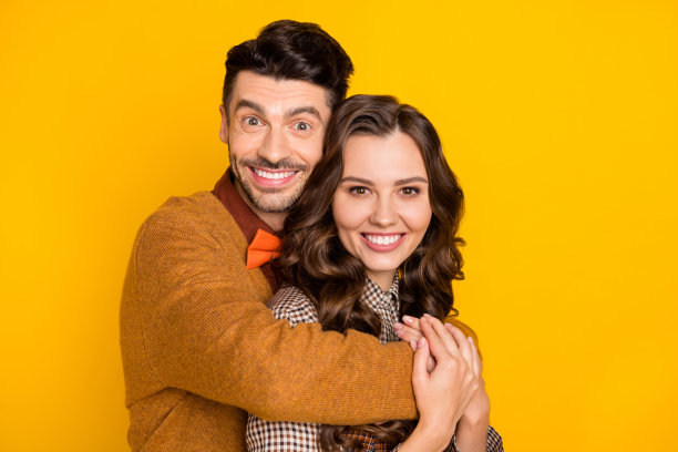 迷人的夫妇拥抱好心情微笑和谐家庭孤立在亮黄色背景照片图片下载