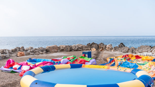 充气水上乐园玩具在亚得里亚海，帆船在背景股票照片图片下载
