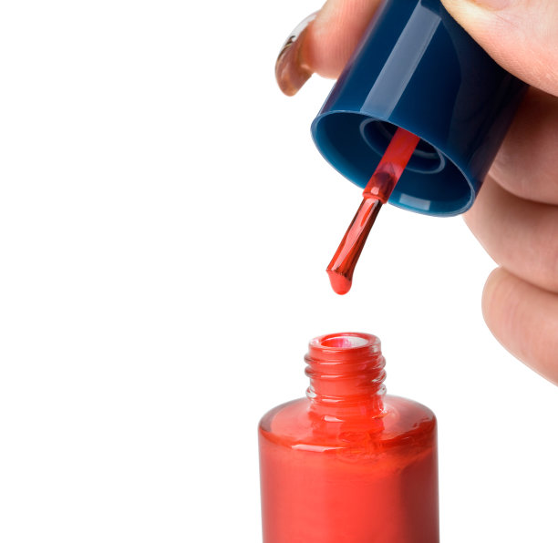 女性双手正在做指甲，指甲油颜色为红色图片下载